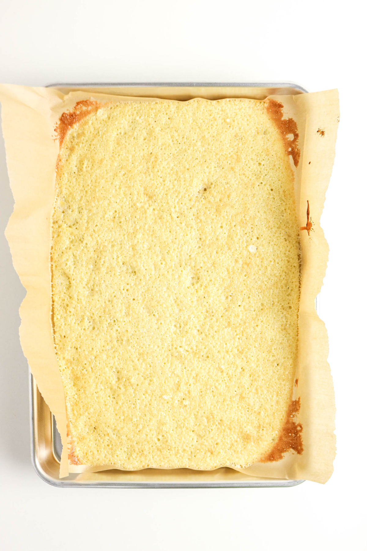 Banana cake cooked in a parchment lined baking pan.