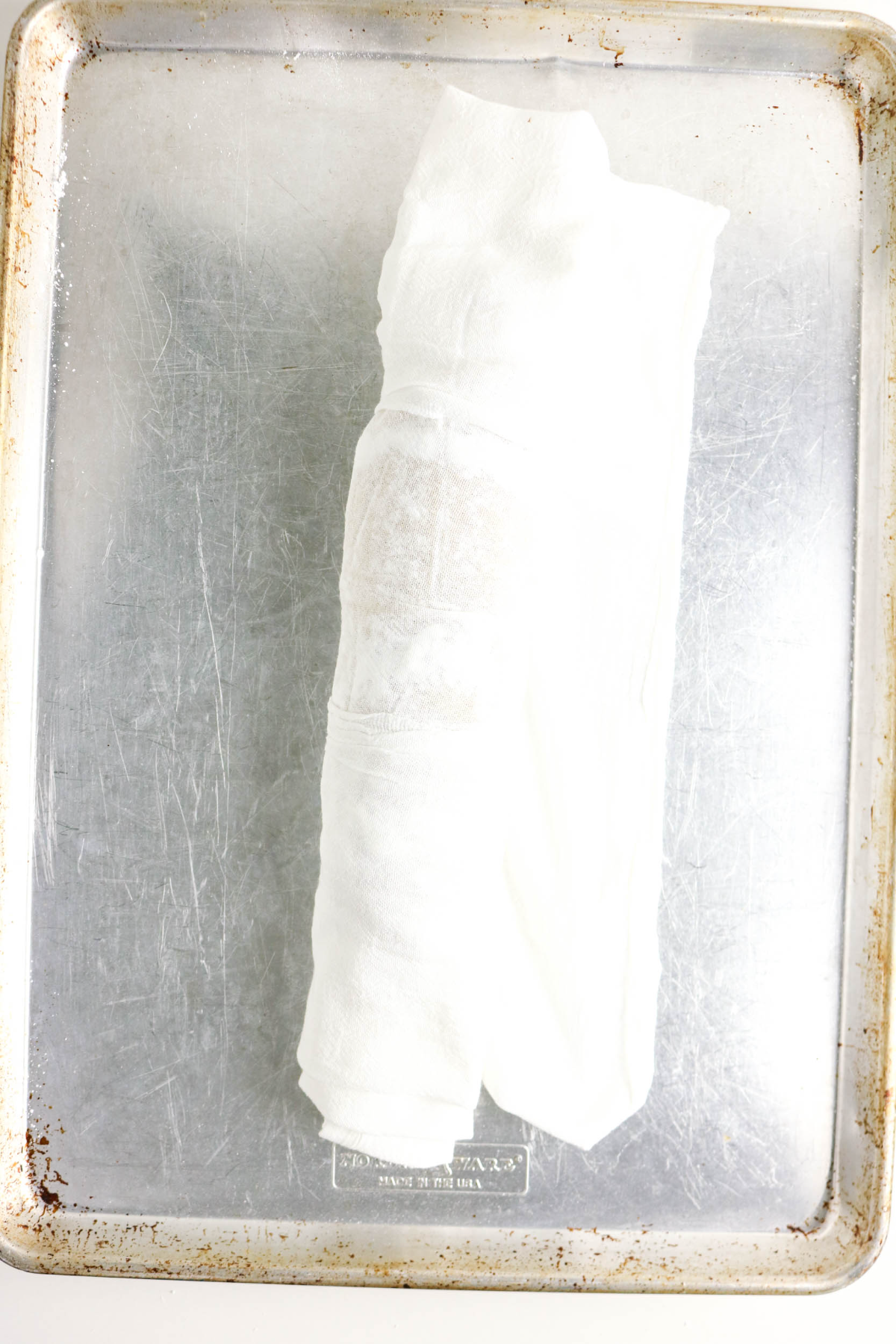 Cooked banana cake rolled in a clean towel cooling before adding filling.