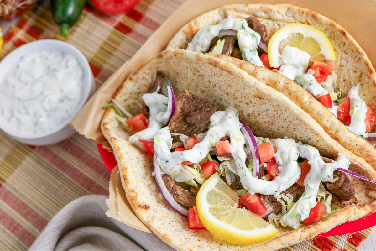 Pita wrap with beef in a red serving basket.
