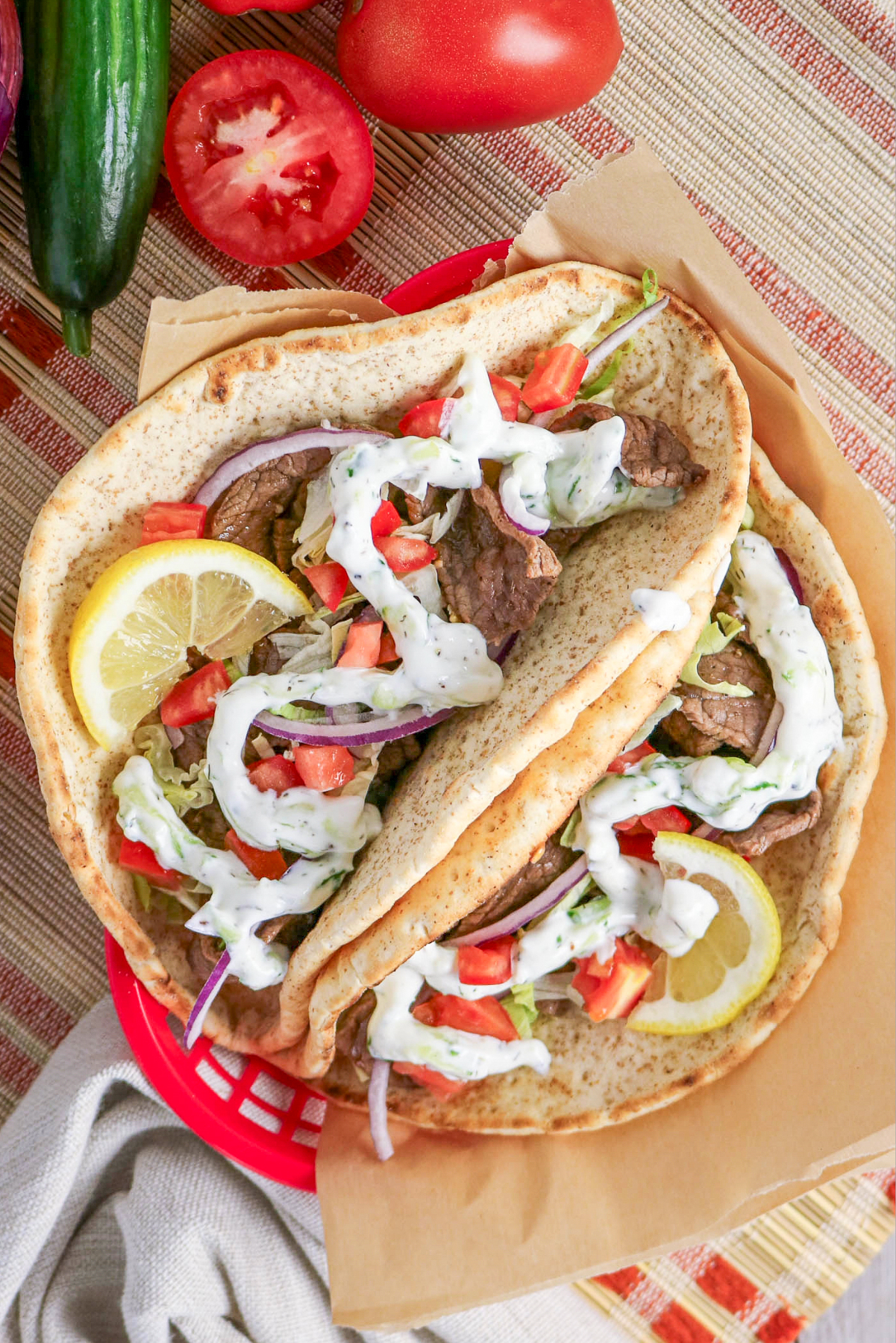 Beef gyros in a red basket lined with parchment paper.