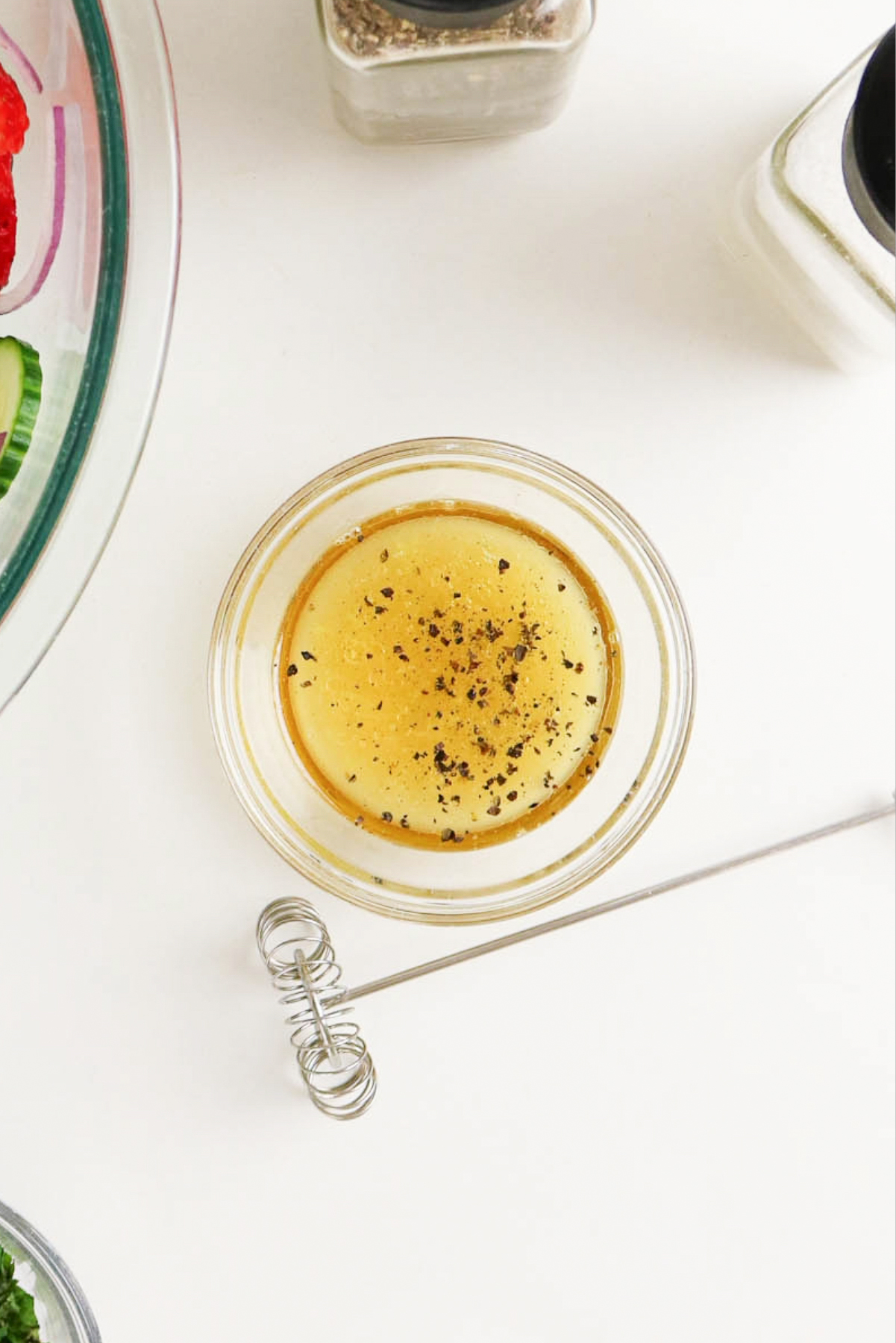 Honey lime dressing with a whisk on the side.