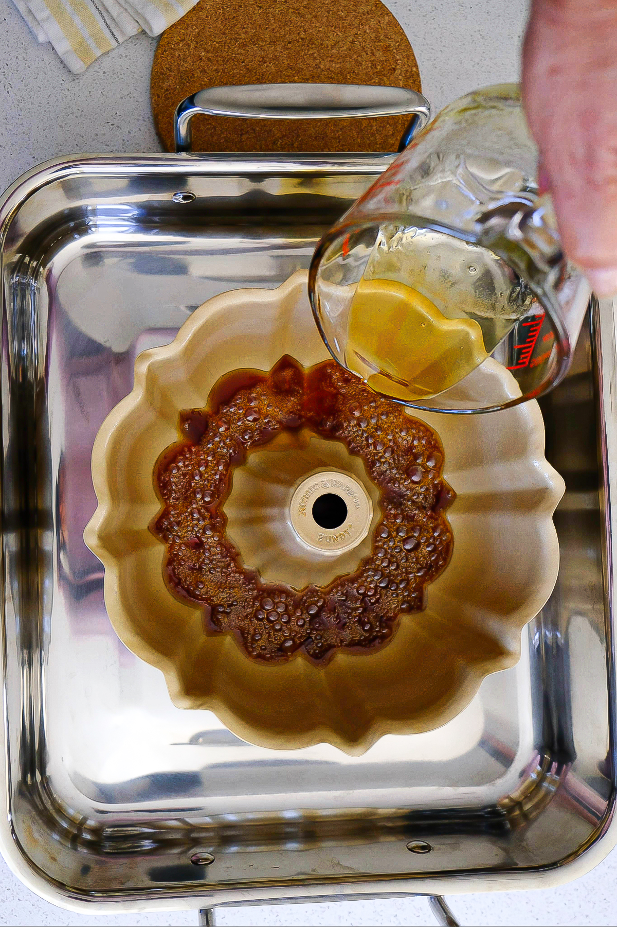 Pouring caramel sauce in a bundt cake pan.