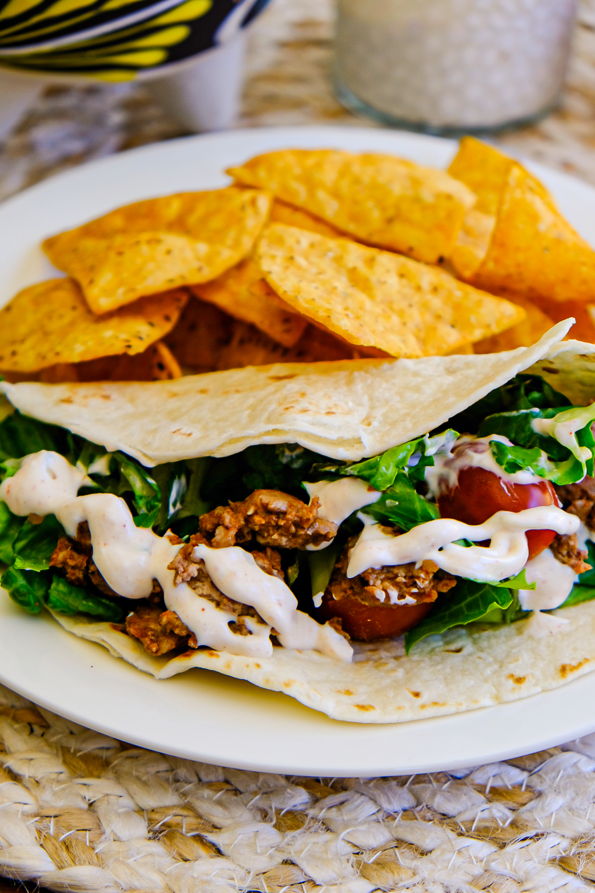 Taco in a flour tortilla with tortilla chips on the side.