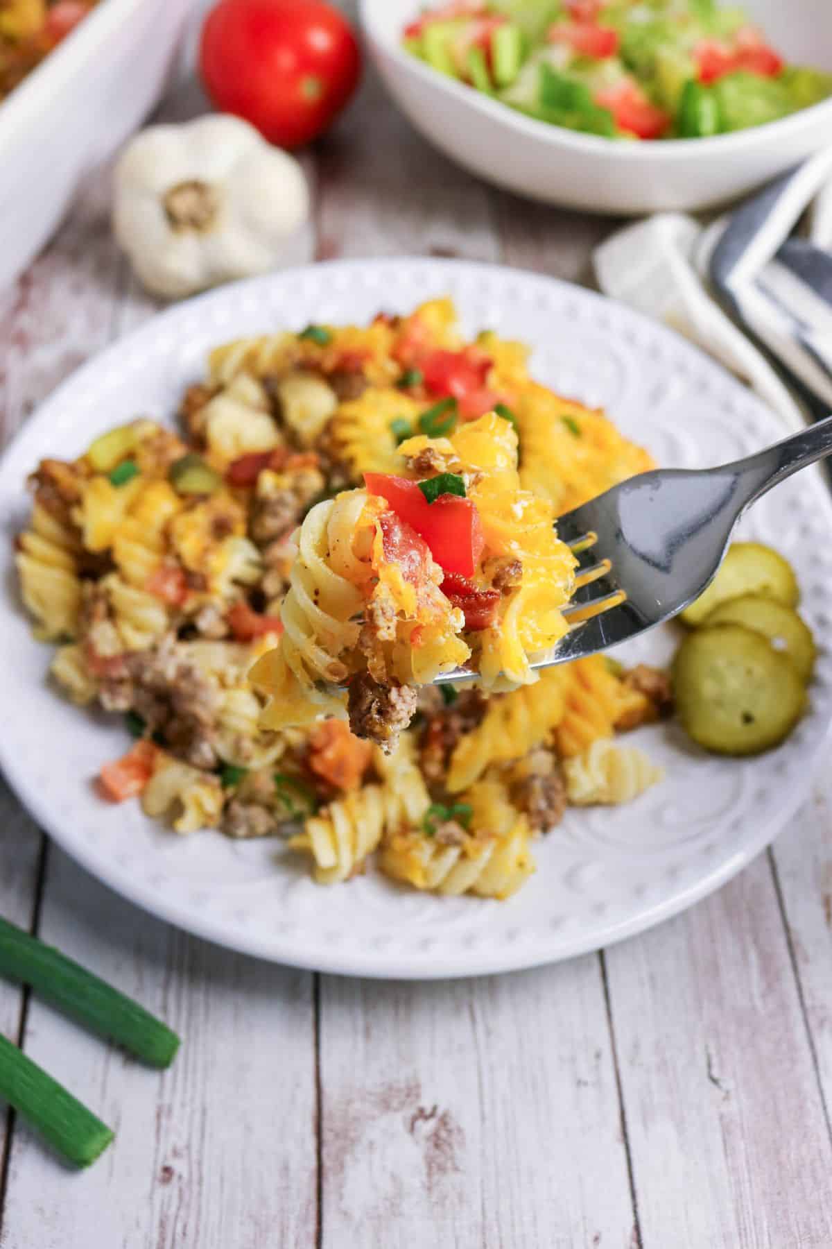 Bacon cheeseburger casserole with pasta on a white plate.