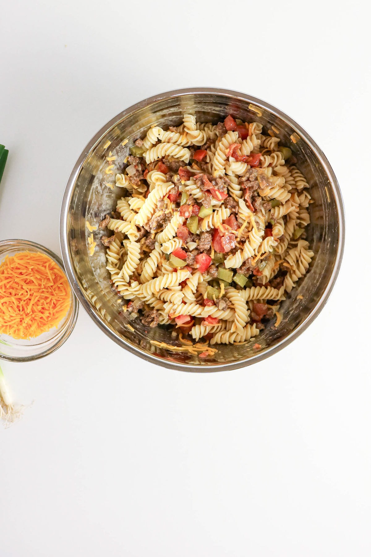 Cooked pasta in a bowl with cooked ground beef.