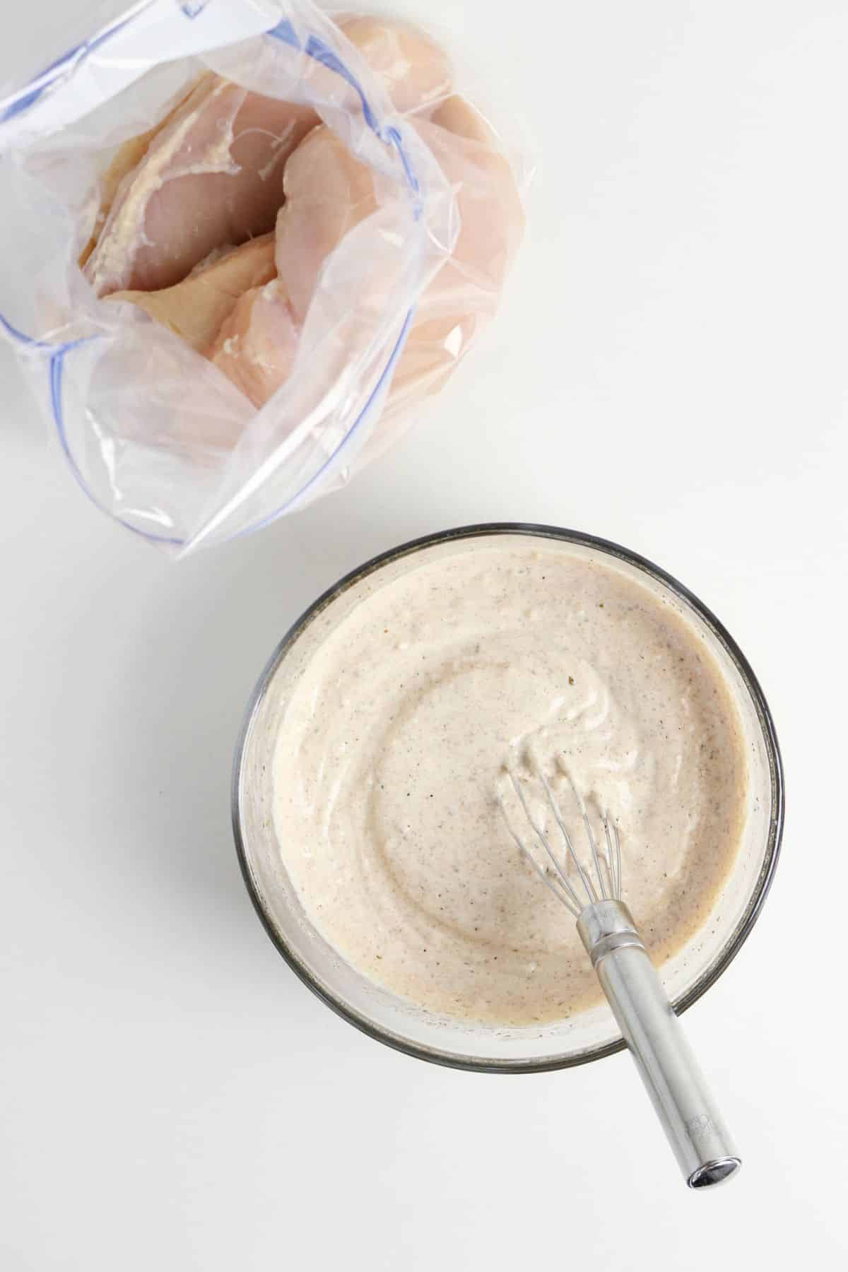 Greek yogurt marinate in a mixing bowl.
