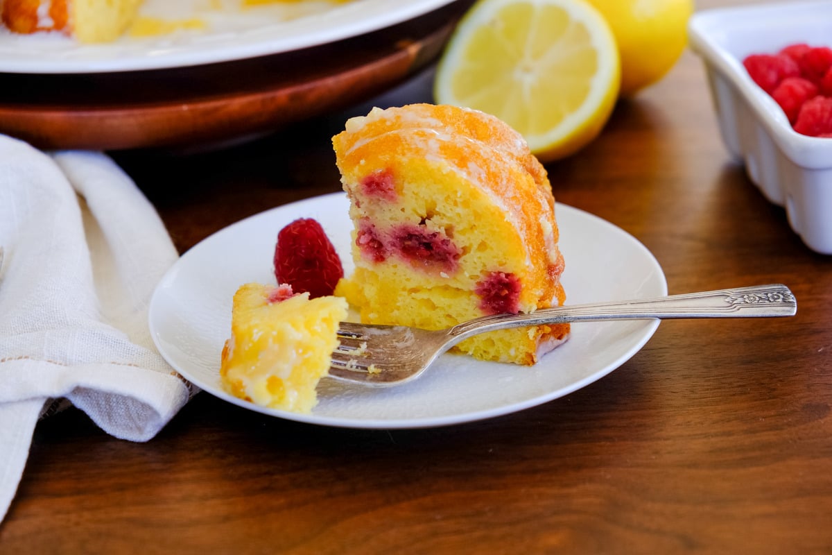 A slice of cake with a piece cut out with a fork.