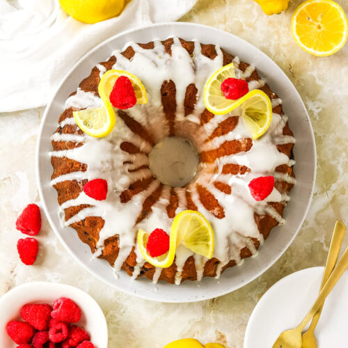 Top view of a lemon raspberry cake on a white platter.
