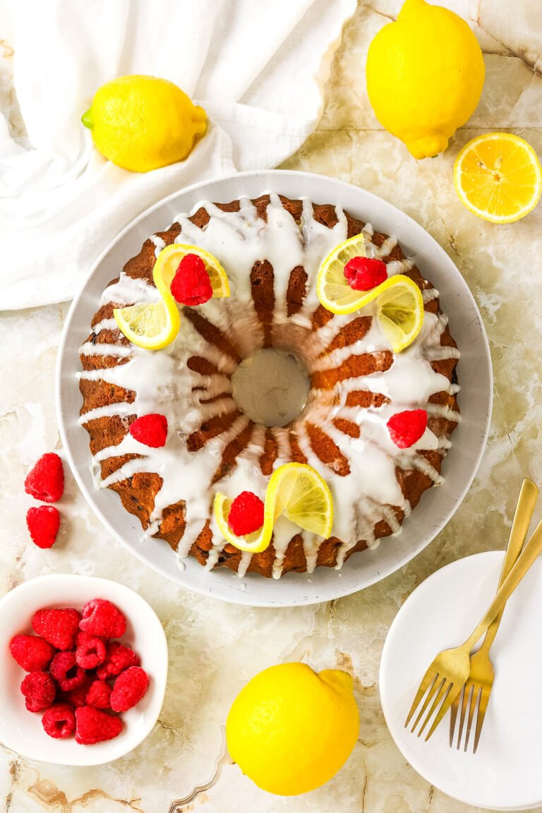 Top view of a lemon raspberry cake on a white platter.