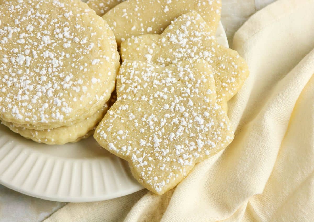 Cutout sugar cookies stacked on a plate.
