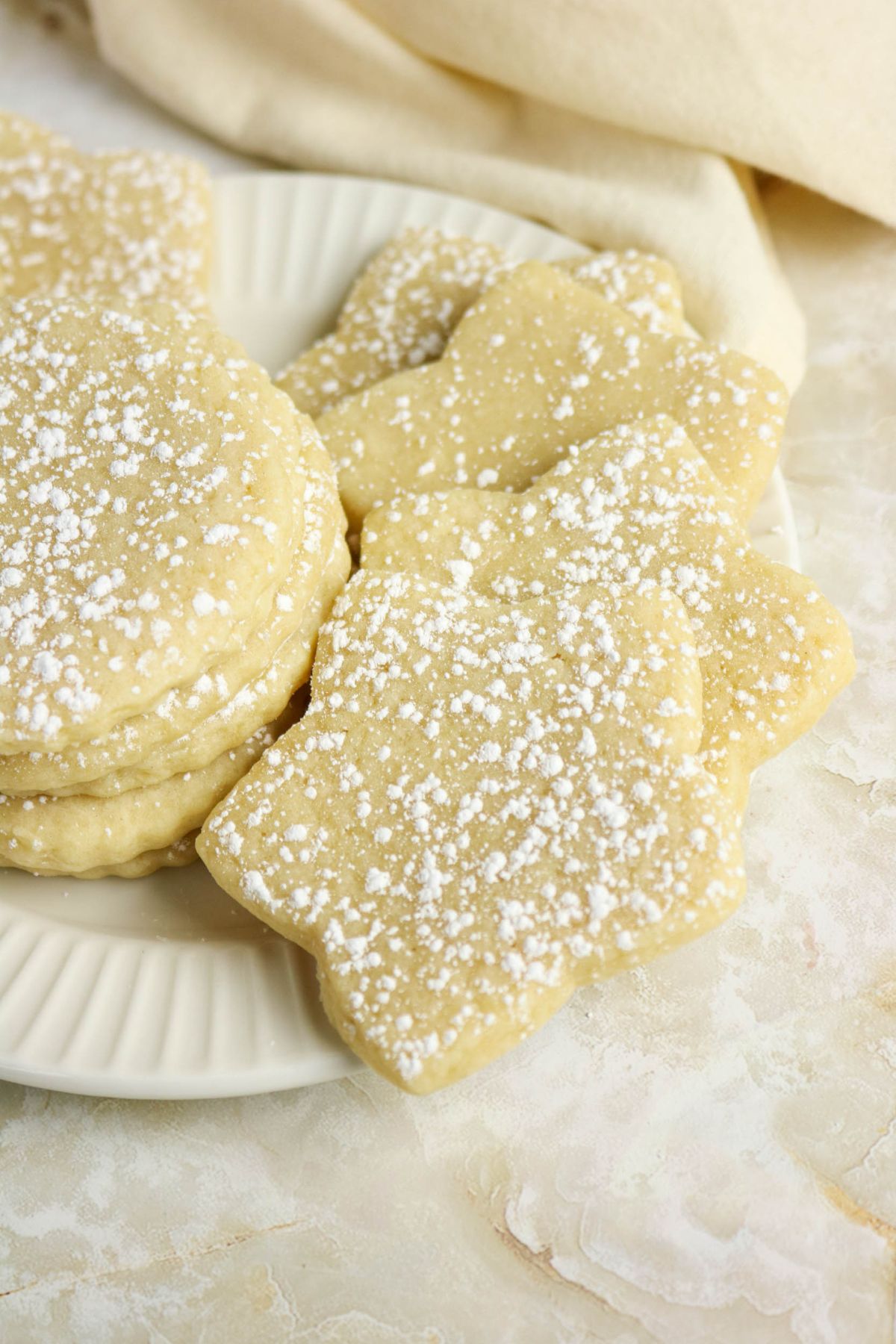 Cutout sugar cookies stacked on a plate.