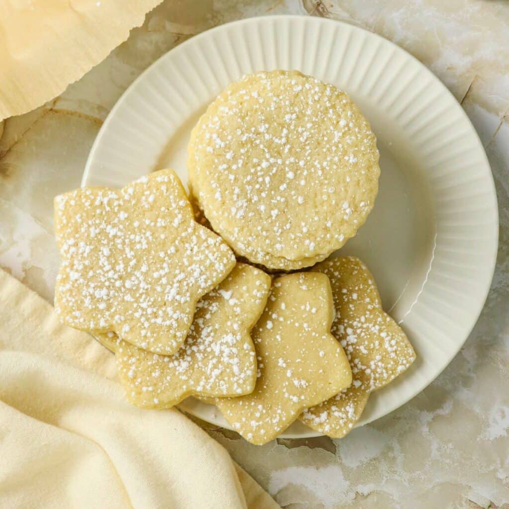 Cutout sugar cookies stacked on a plate.