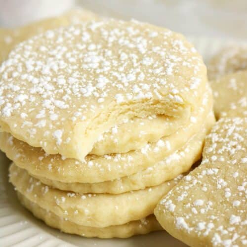 Cutout sugar cookies stacked on a plate.
