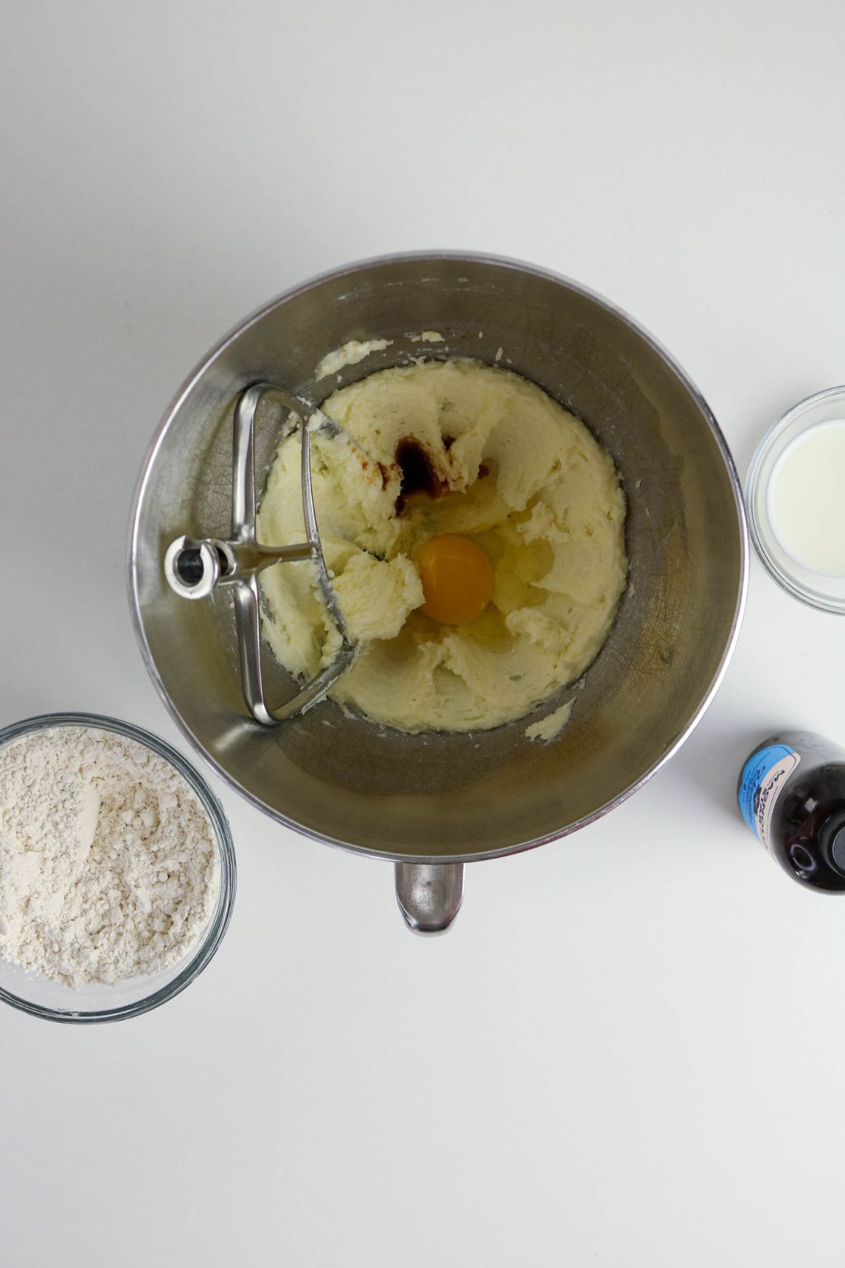 Egg and vanilla being mixed into creamed butter and sugar.