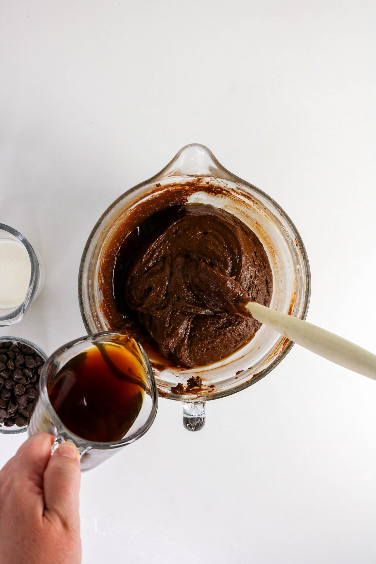 Adding coffee to wet and dry cake ingredients.