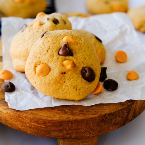 Homemade chocolate chip peanut butter chip cookies on a wooden stand.
