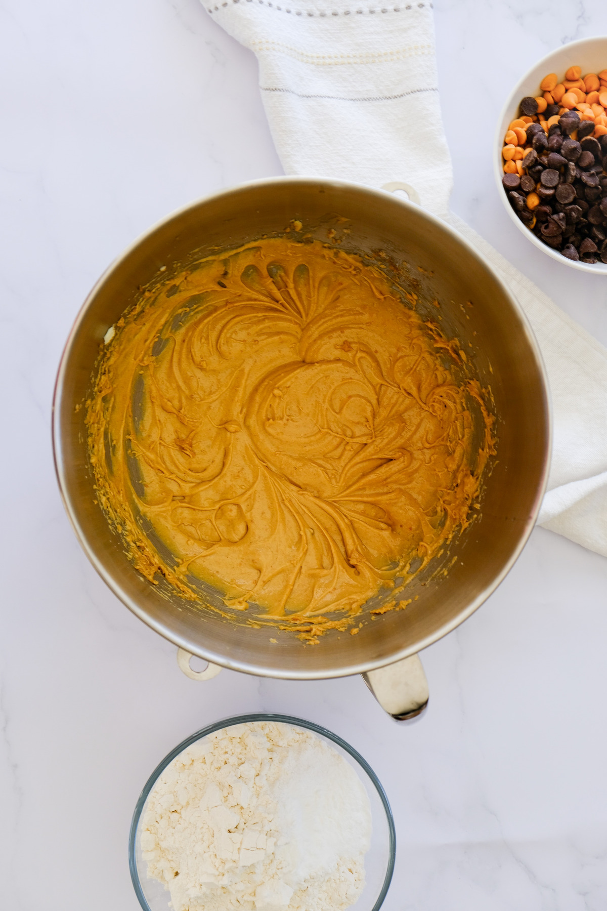 Flour mixture next to creamed mix to make cookie dough.