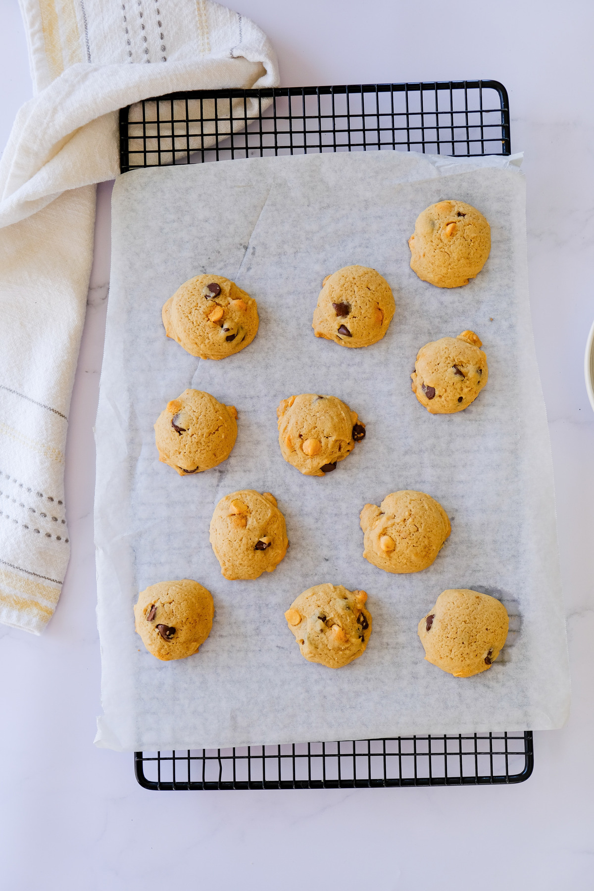 Baked cookies on parchment paper over a cooling rack.
