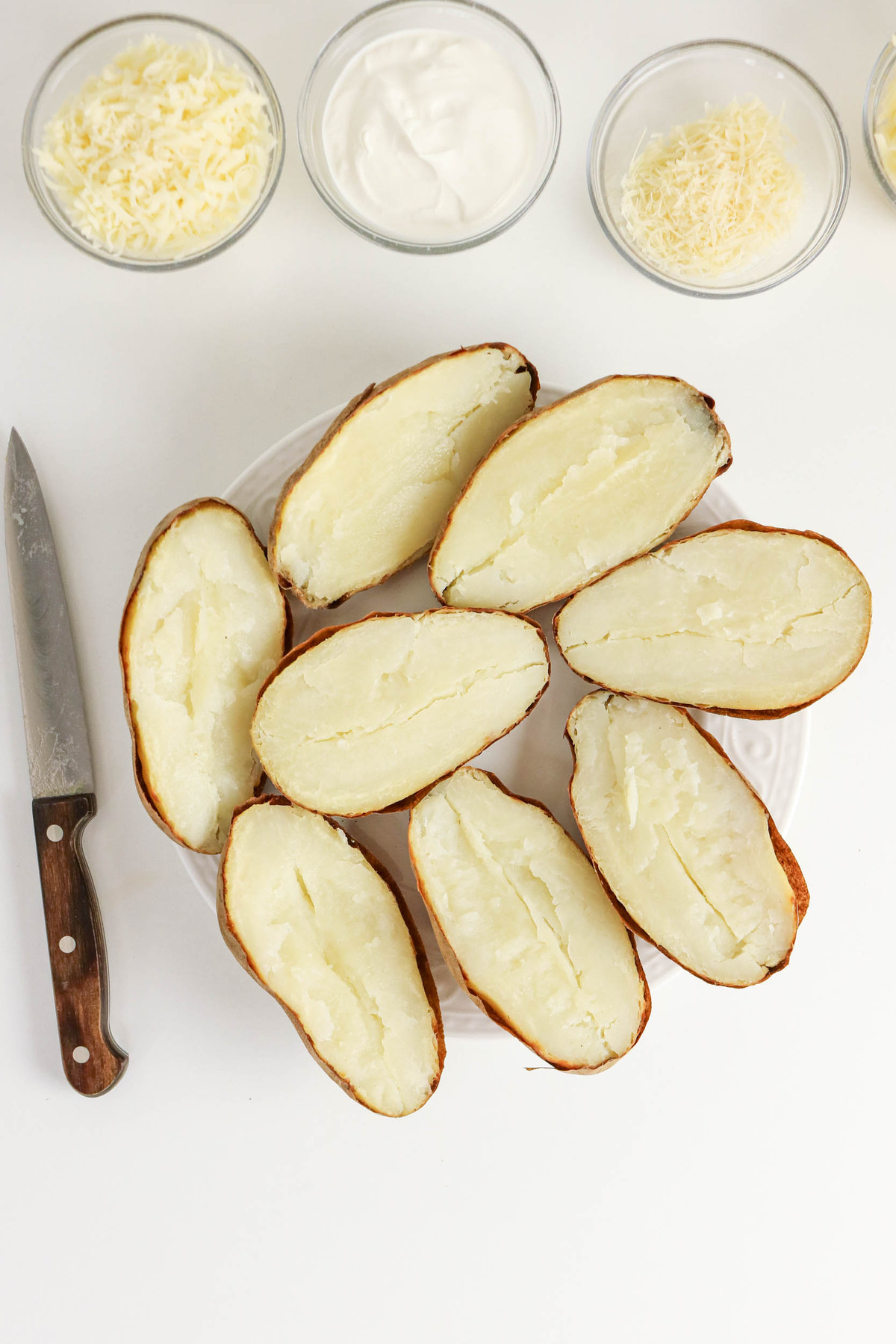 Cooked baked potatoes sliced in half.