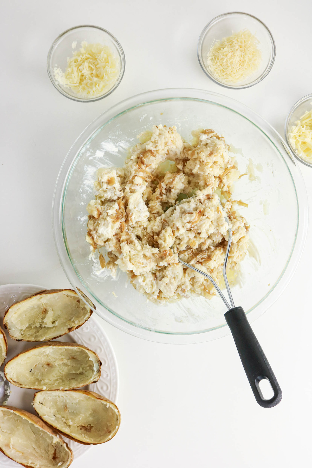Potato filling mixed with sour cream in a mixing bowl before placing in potato boats.