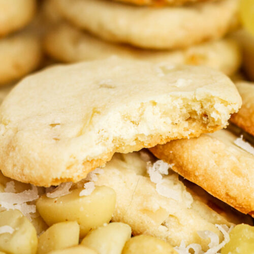 A stack of shortbread cookies with macadamia nuts on the side.