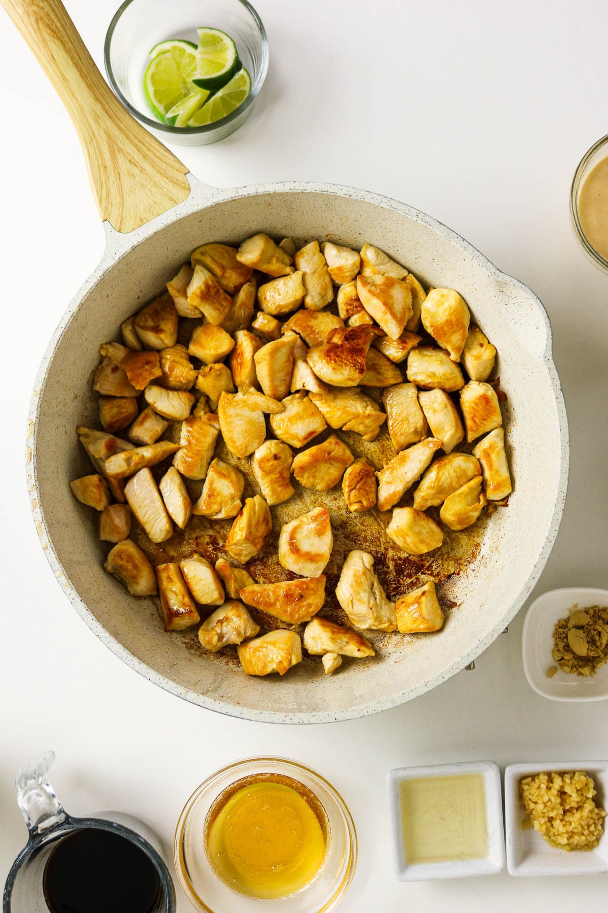 Diced chicken browning in a skillet.