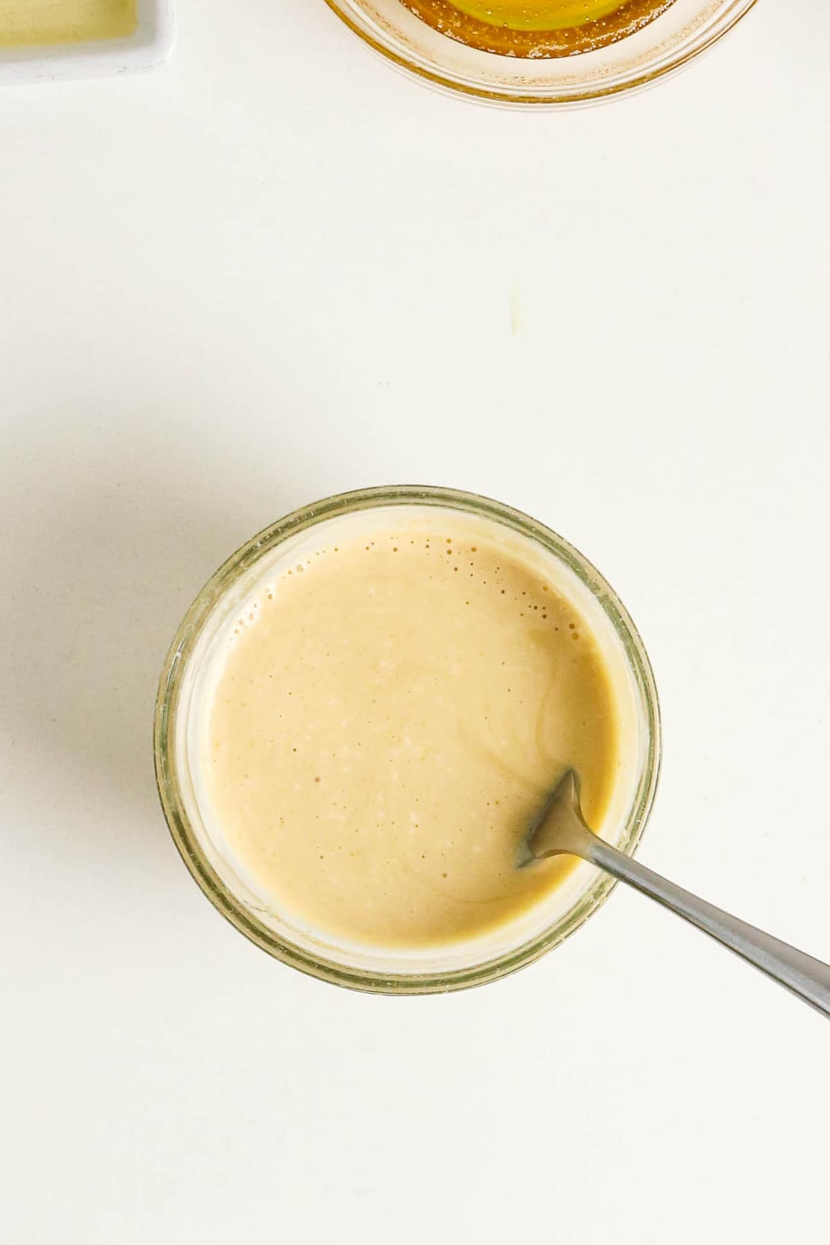 Mayonnaise sauce in a small clear mixing bowl.