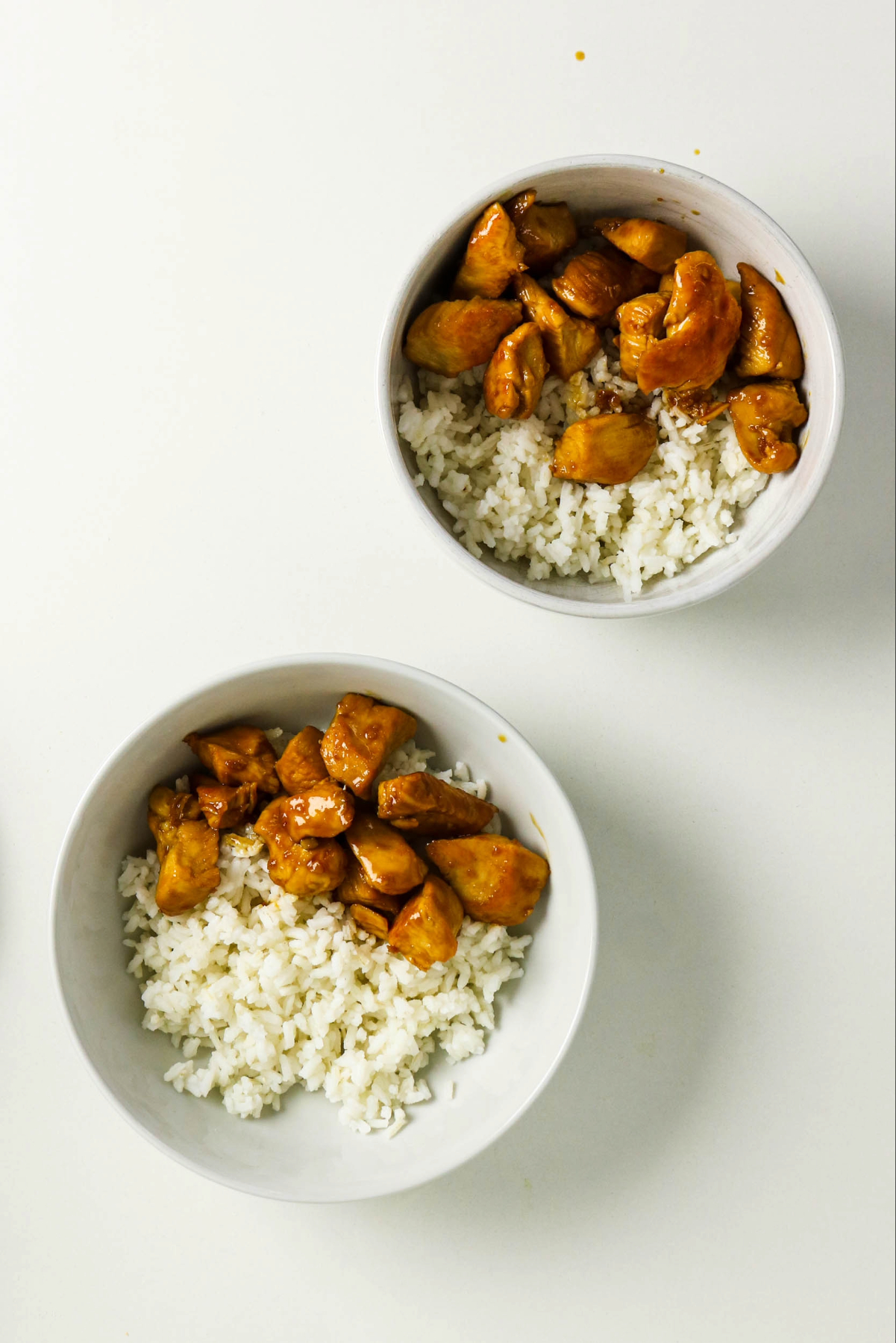 Rice and prepared chicken in serving bowls.
