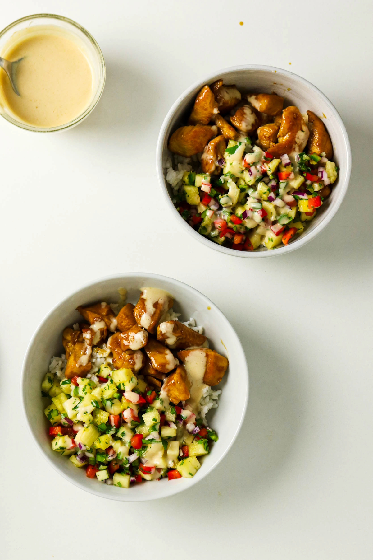 Pineapple and sauce over chicken and rice bowls.