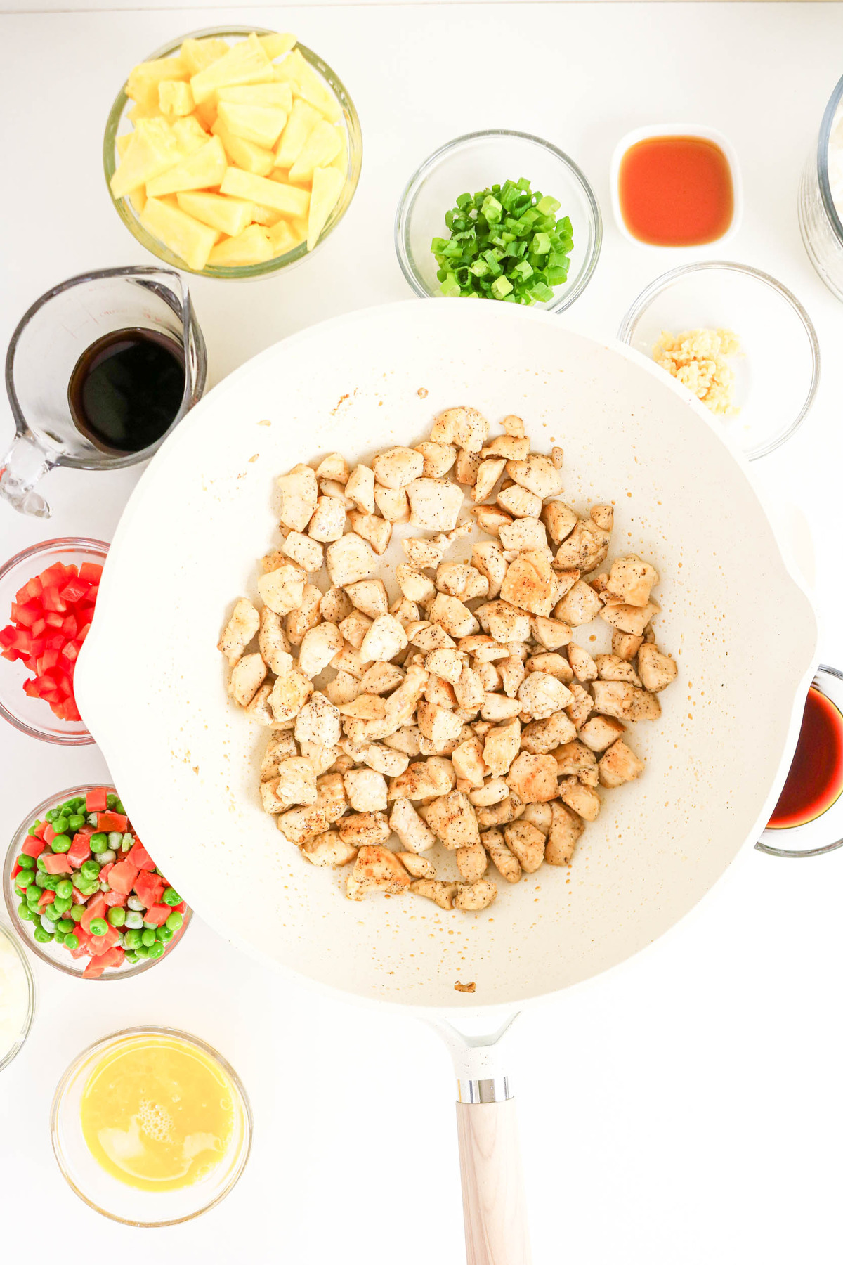 diced chicken browning in a large skillet pan.