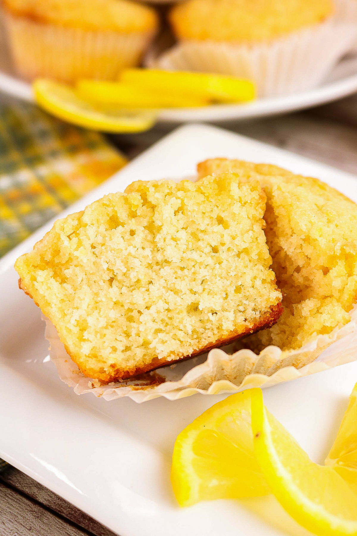 A lemon muffin cut open on a white square dish.