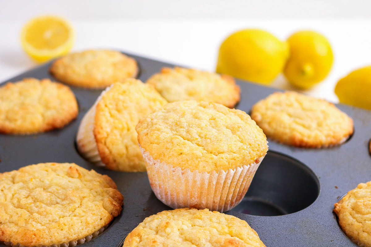 Lemon muffins cooling in a muffin tin.