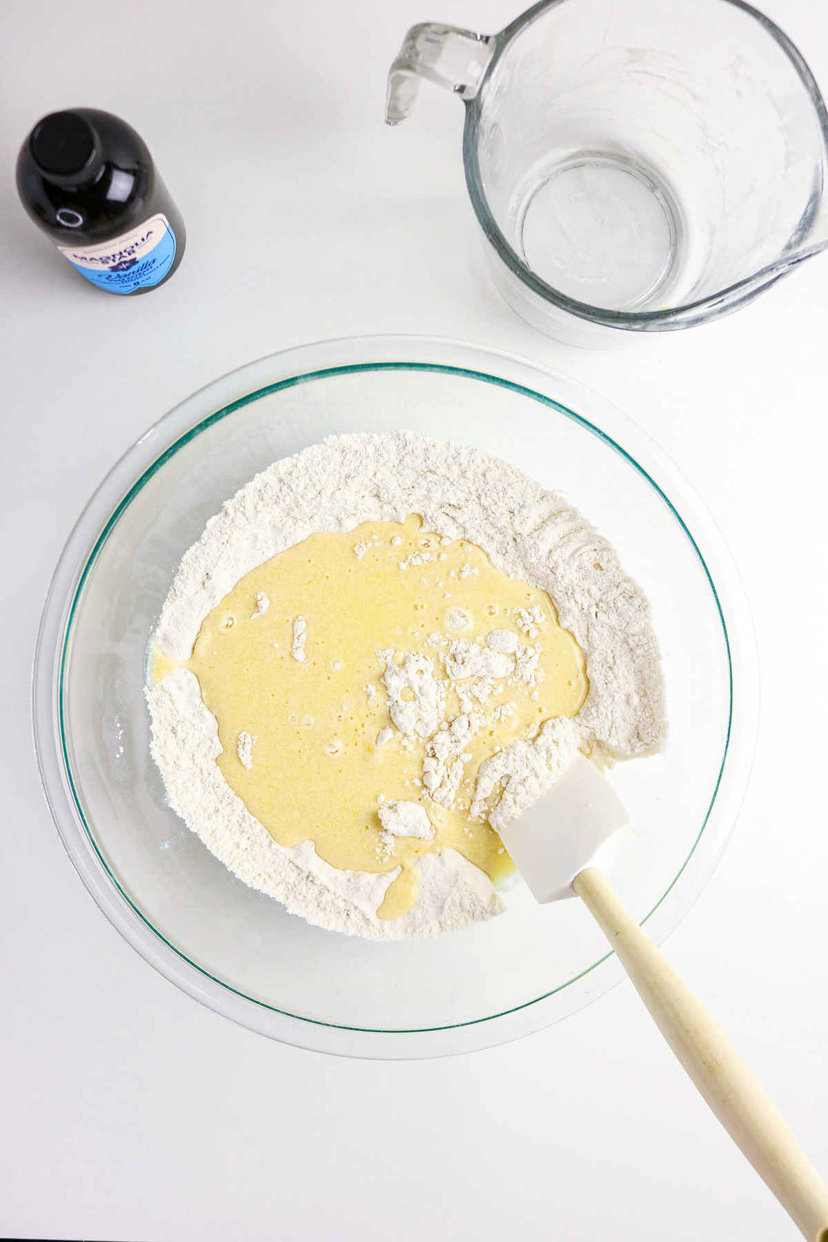 Wet and dry ingredients to make muffins in a clear mixing bowl.