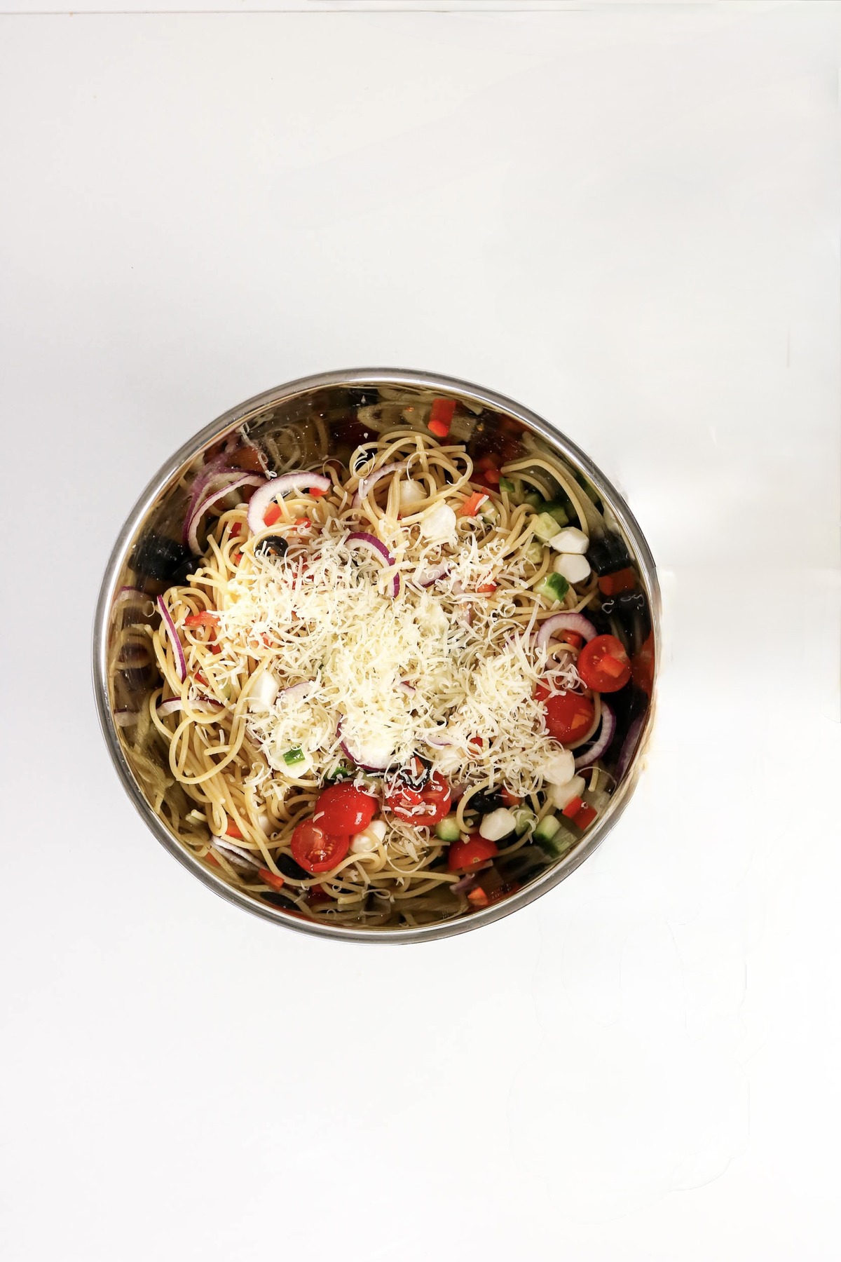 Cheese added on top of pasta dressed with Italian dressing.