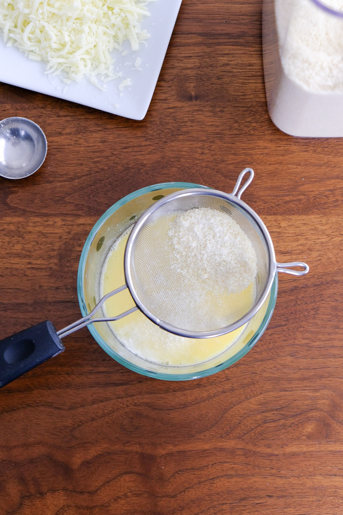 Almond flour and baking powder sifted over egg mx.