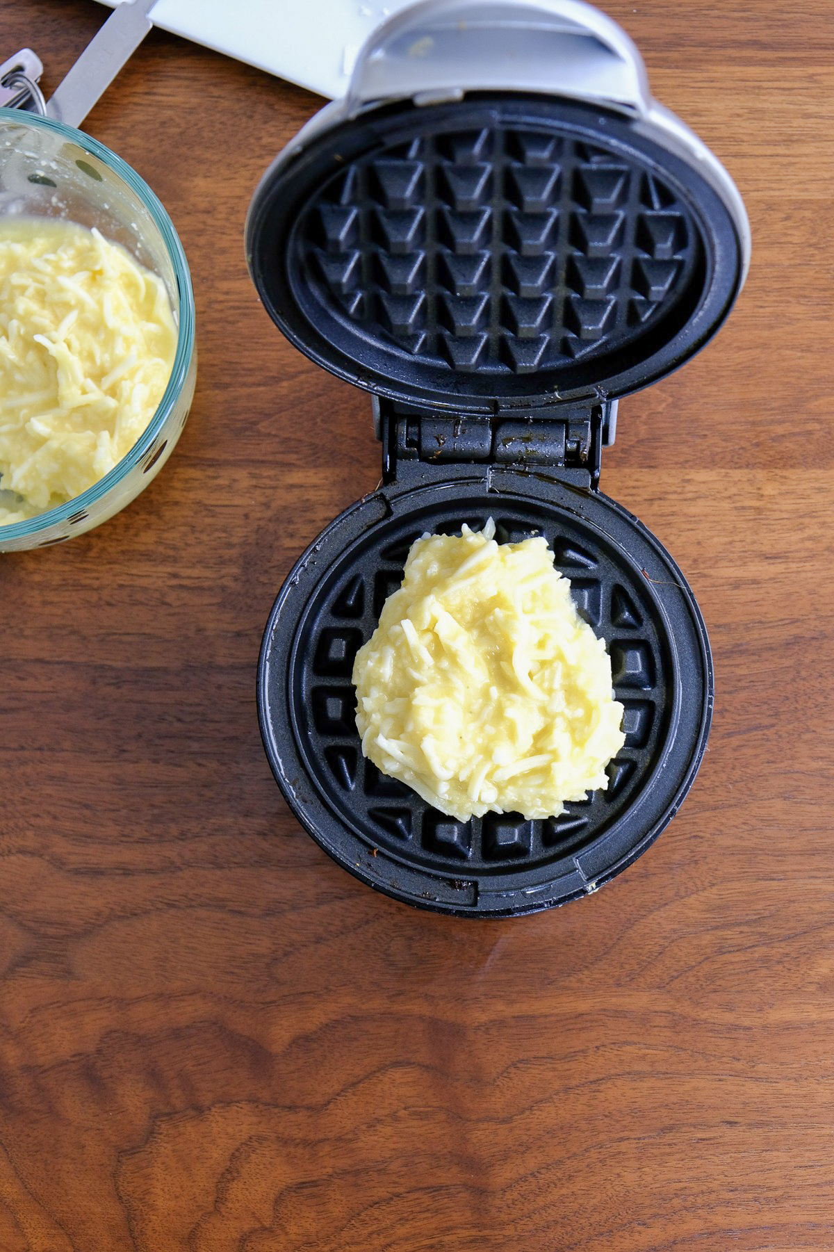 Batter placed in the center of a mini waffle maker.