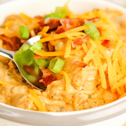 cheeseburger dip in a white serving bowl with a spoon.