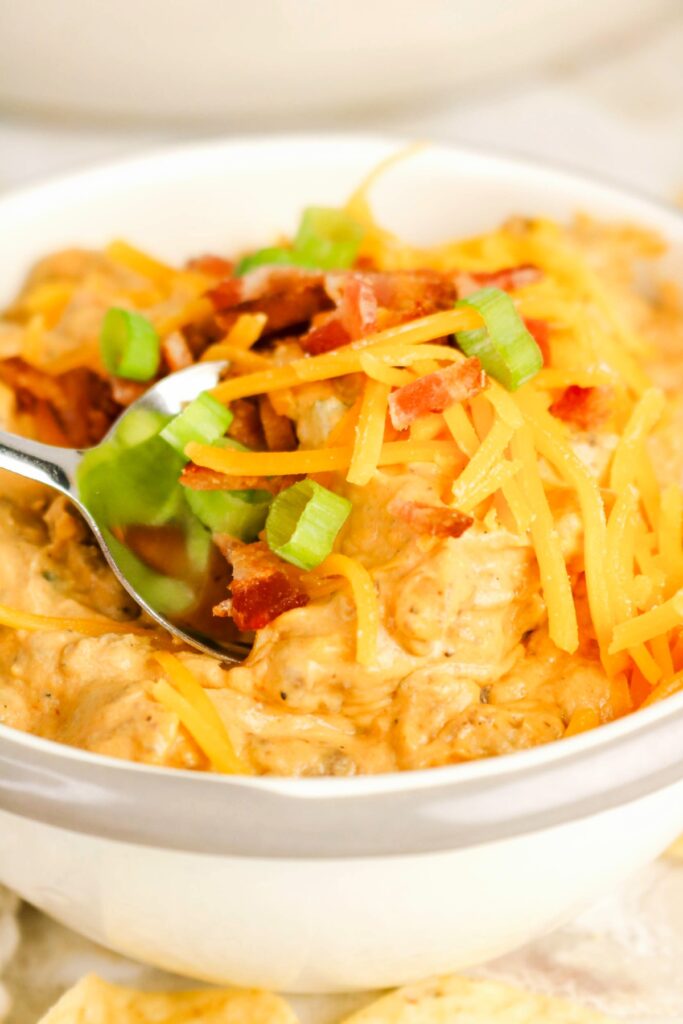 cheeseburger dip in a white serving bowl with a spoon.