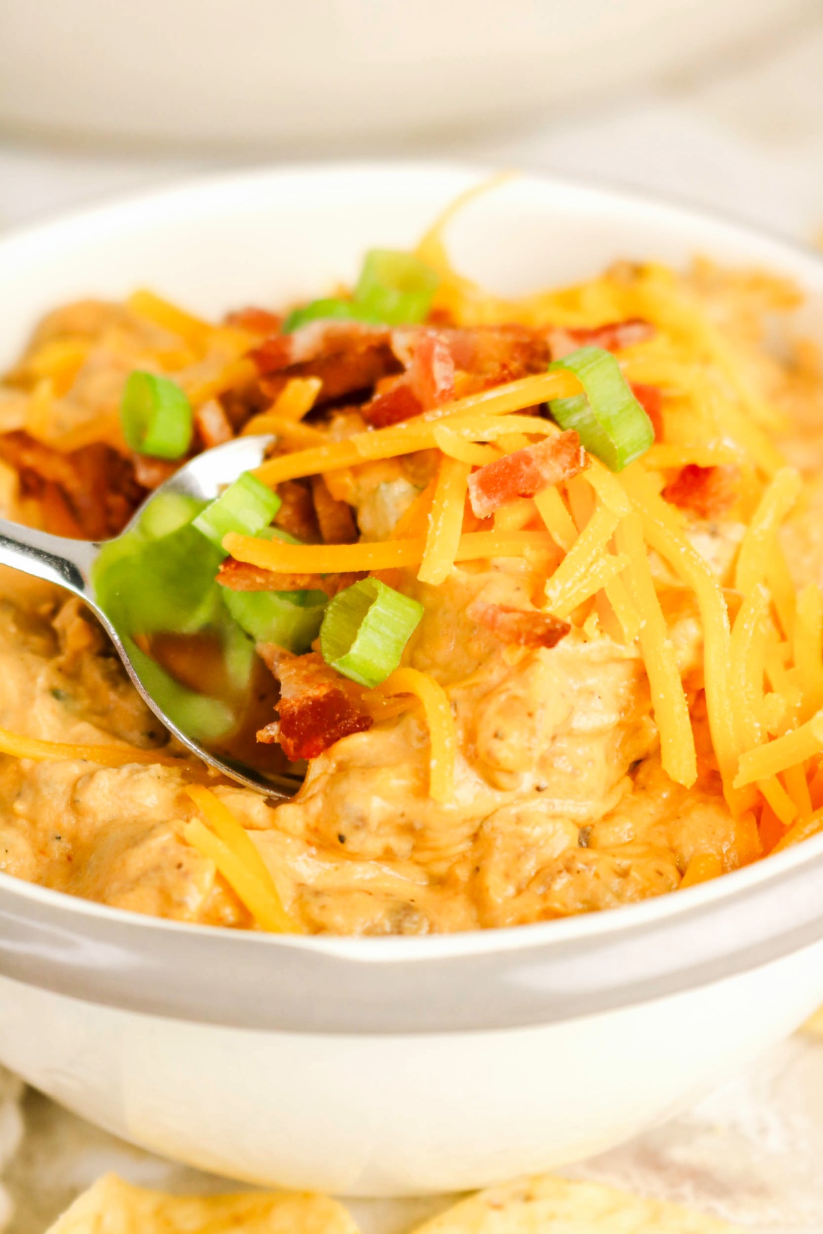 cheeseburger dip in a white serving bowl with a spoon.