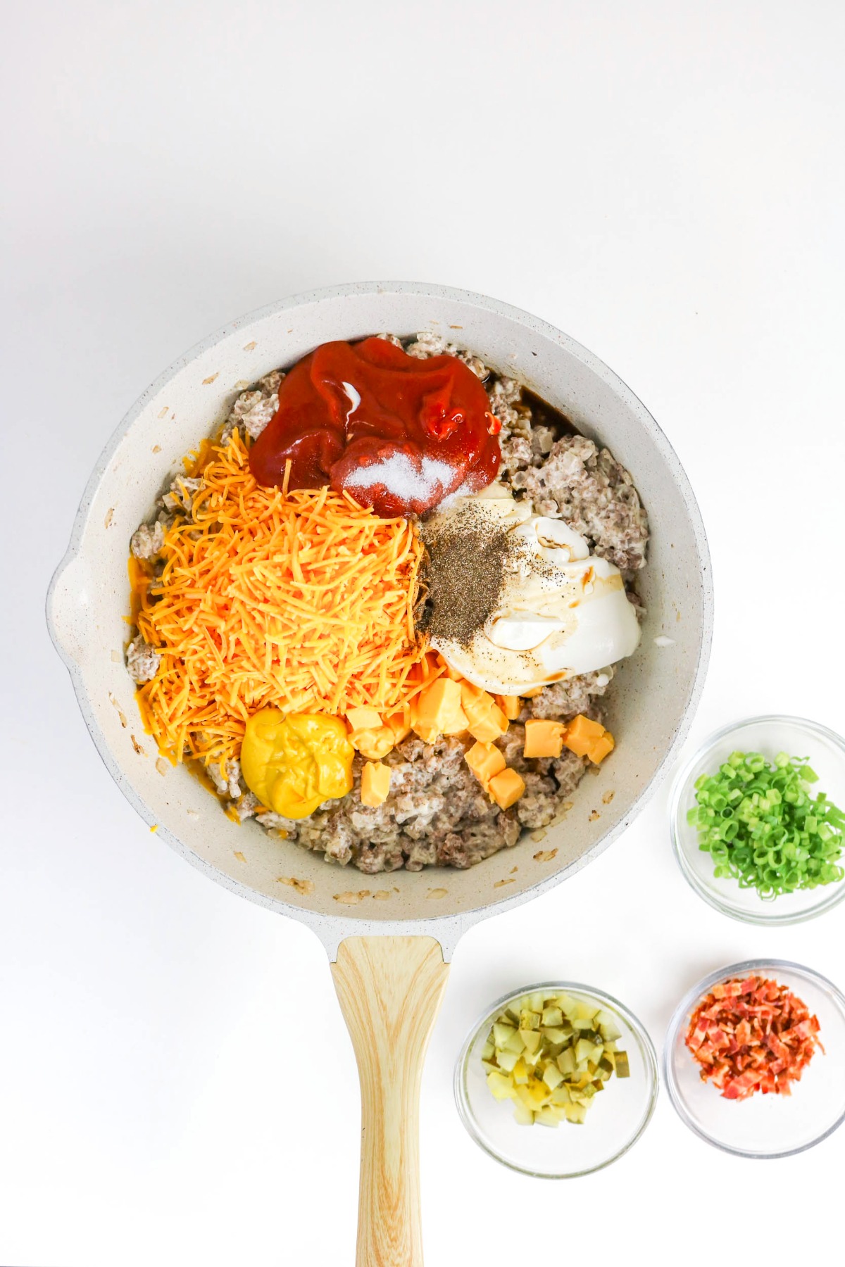 Cheese and spices in a large skillet with ground beef.