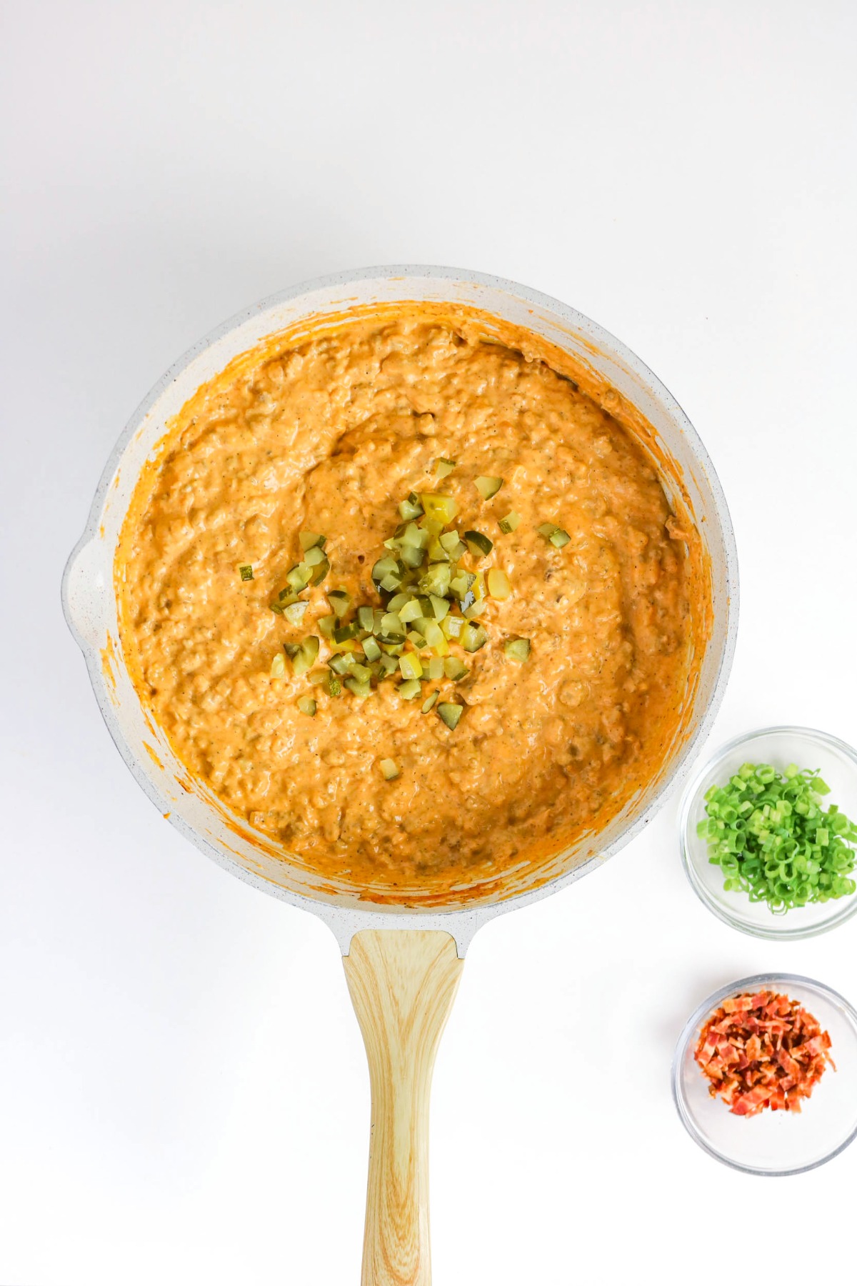 Melted cheese with cooked ground beef with chopped pickles.