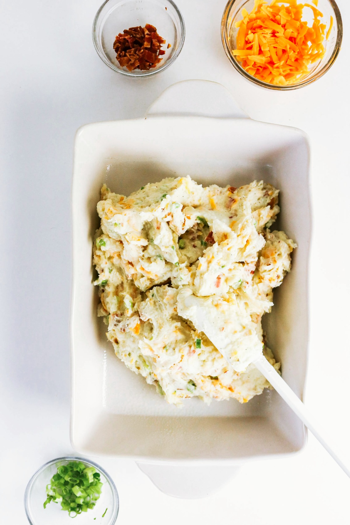 Folded ingredients added to a white baking dish.