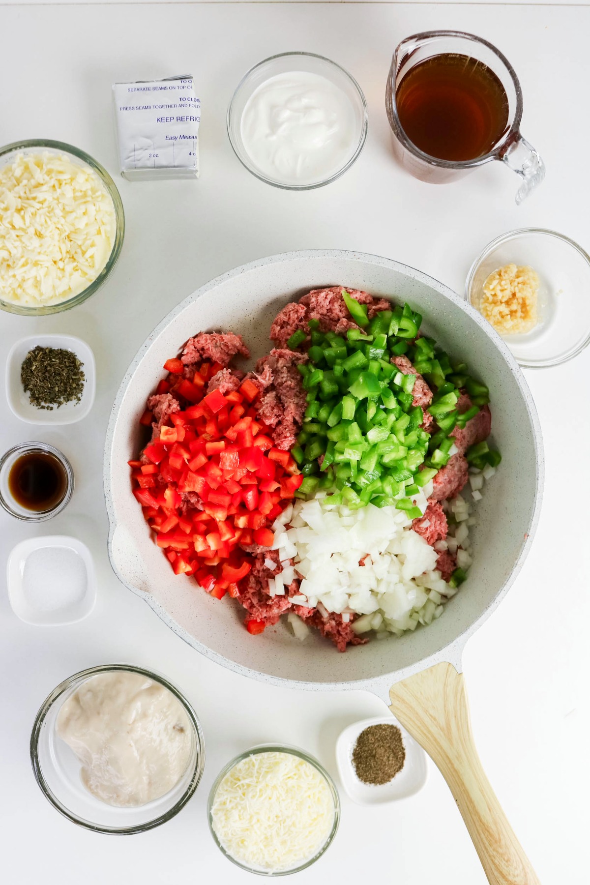 Diced peppers and onion in a skillet with ground beef.