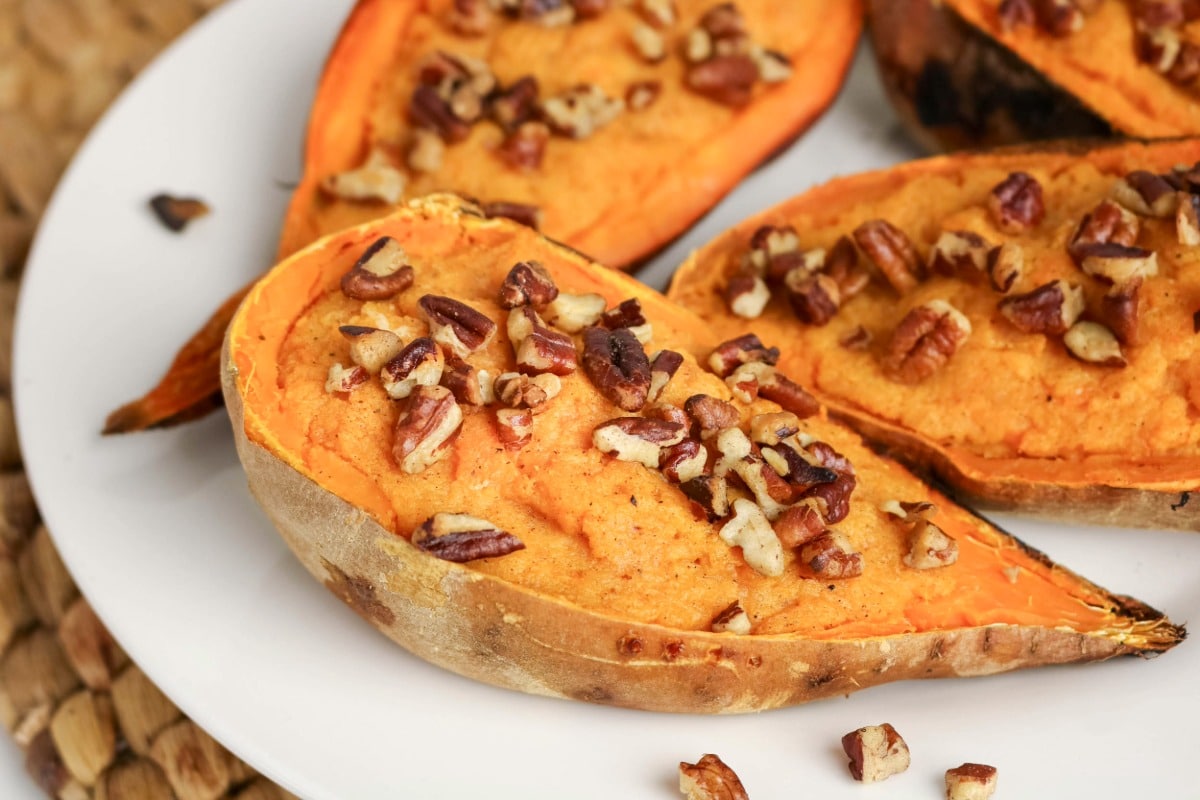 Sliced baked sweet potatoes on a serving plate.