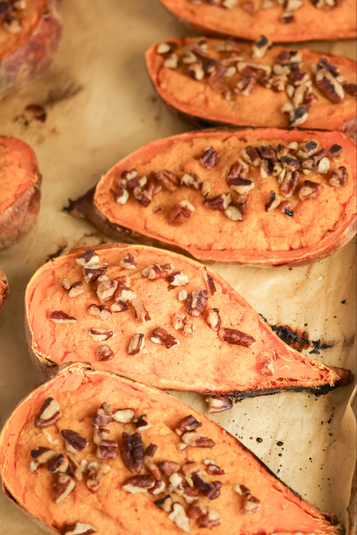 Sliced baked sweet potatoes on a baking sheet before serving.