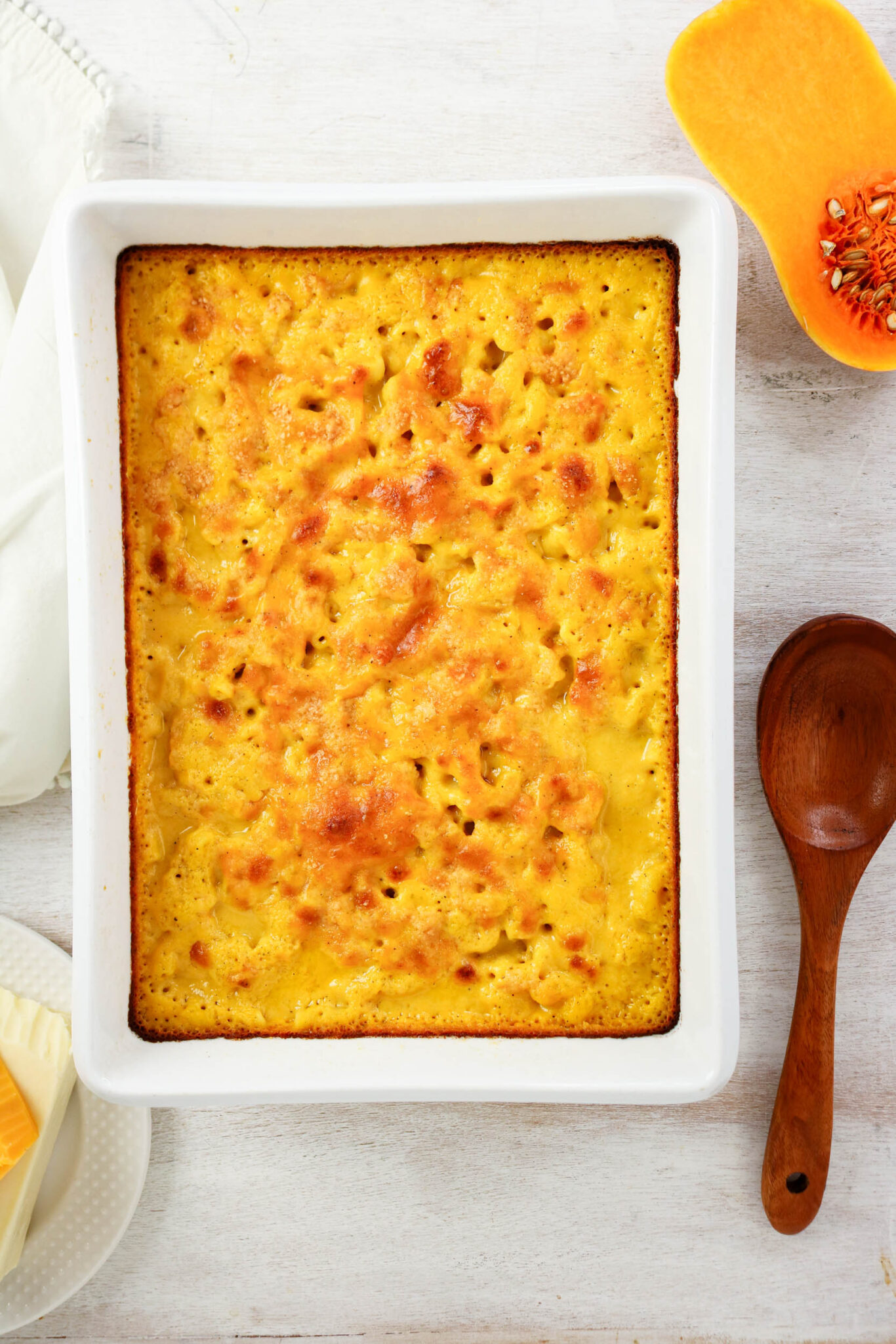 Cooked mac and cheese in a white casserole baking dish.