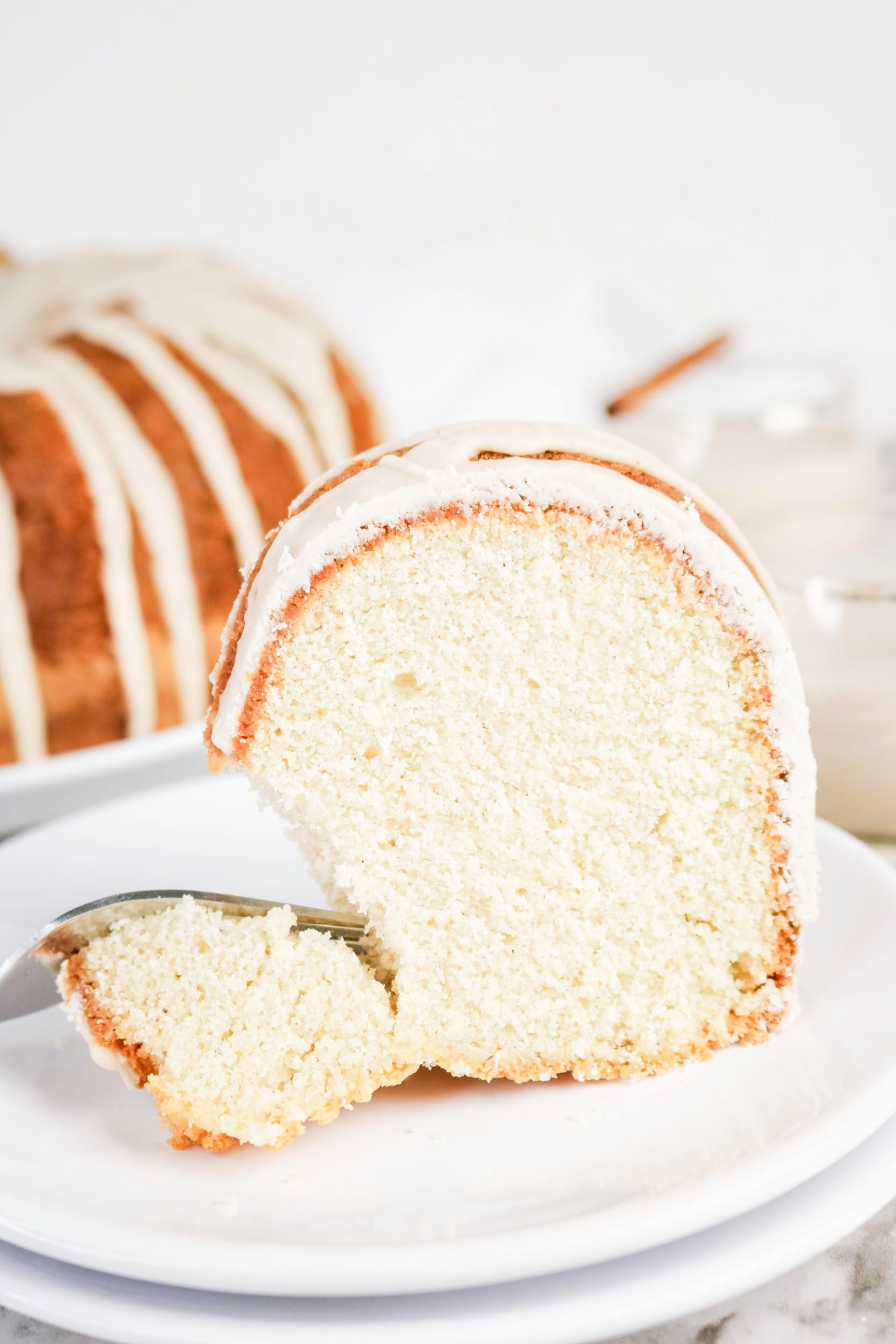 A slice of cake with a fork grabbing a bite before eating.