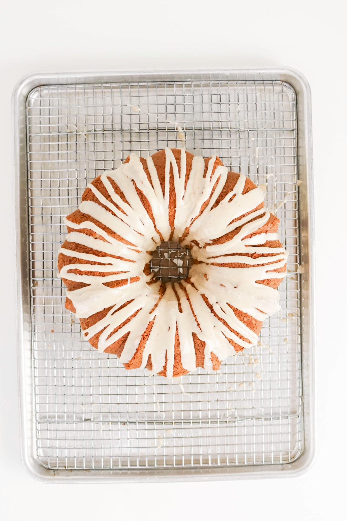Glaze poured over pound cake on a baking rack.