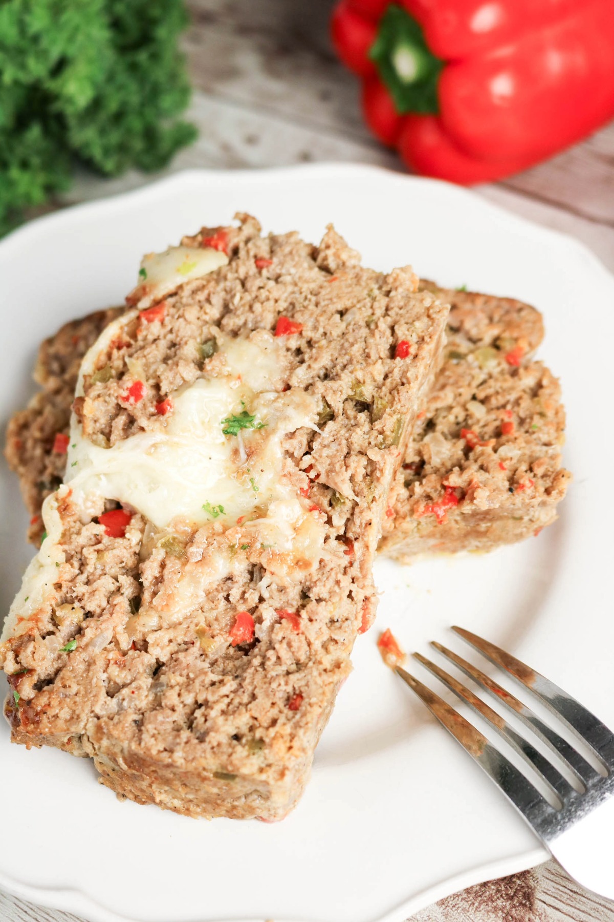 Two slices of Philly cheesesteak meatloaf on a dinner plate.