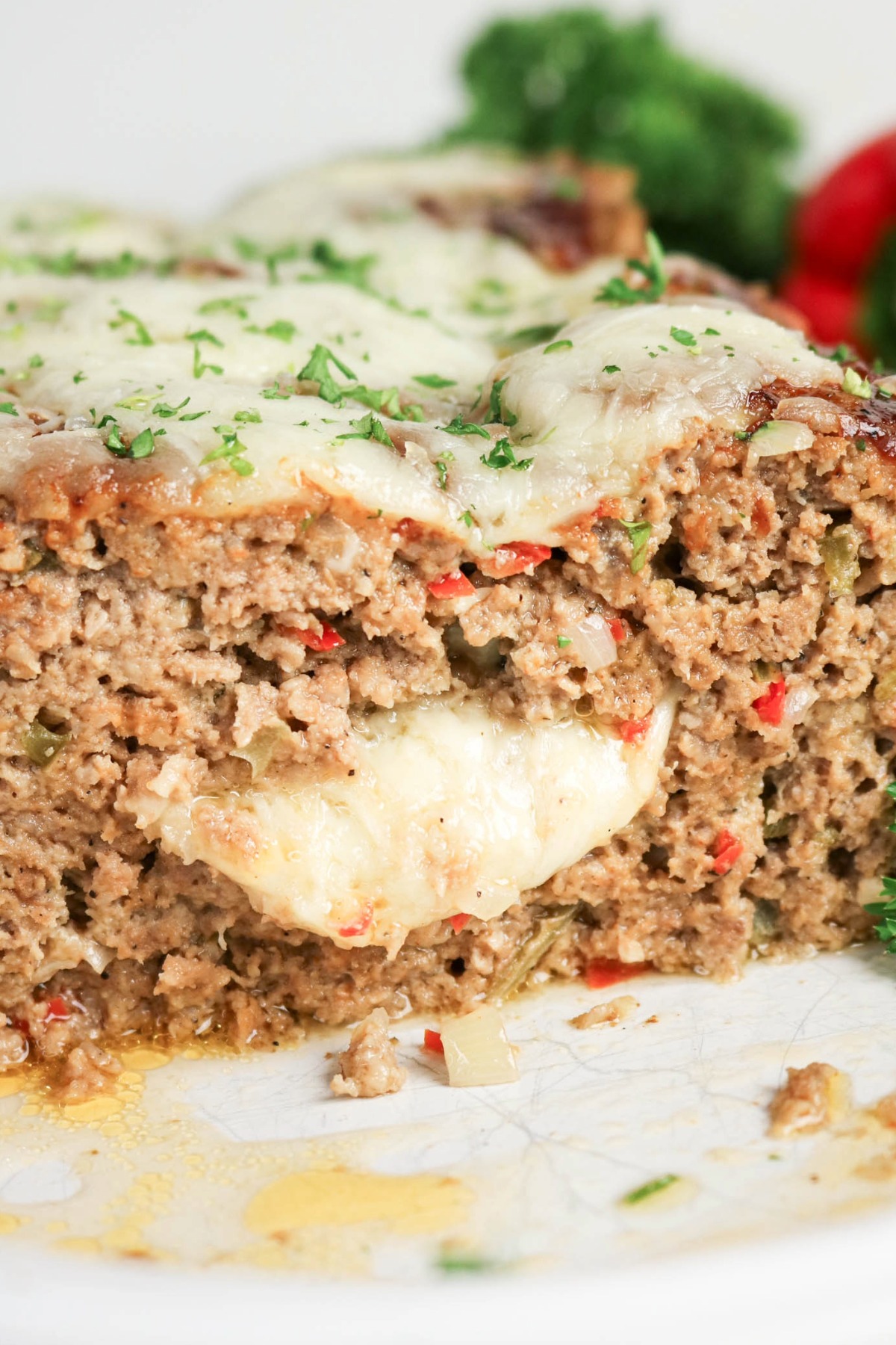 Sliced Philly cheesesteak meatloaf with cheese oozing out of the center.